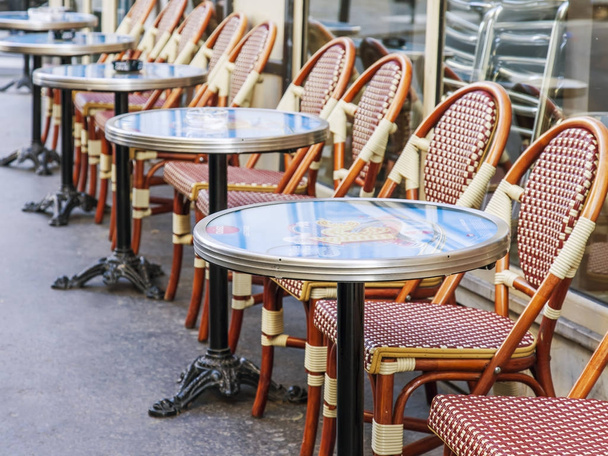 PARIS, FRANCE, on October 30, 2017. Empty little tables of traditional cafe stand on the sidewalk and expect visitors.  - Foto, Imagen