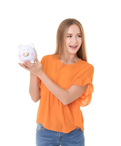 Young woman holding piggy bank on white background - Valokuva, kuva