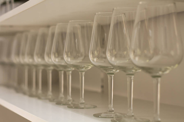 lot clear wine glasses on high leg  in row  on rack sell in the store - Fotografie, Obrázek