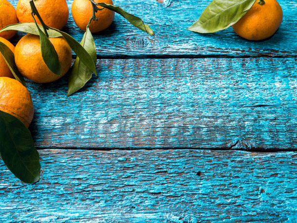 Fresh Mandarin or tangerine with stems and leaves on blue wooden background copy space - Φωτογραφία, εικόνα
