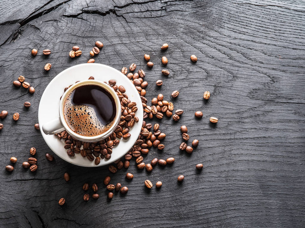 Cup of coffee surrounded by coffee beans. Top view. - 写真・画像