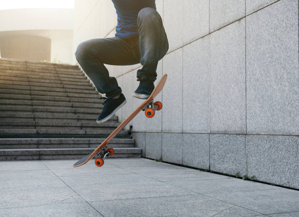 female skateboarder jumping on city with skateboard - Photo, Image