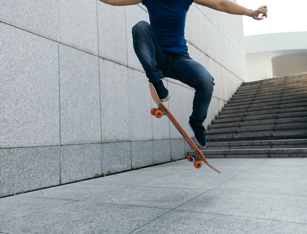Skateboarder jumping on city with skateboard - Фото, изображение