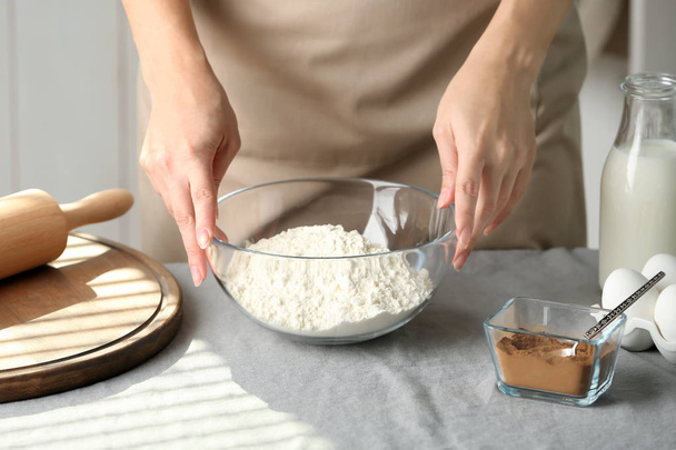 Woman preparing dough for cinnamon buns in kitchen - Fotografie, Obrázek