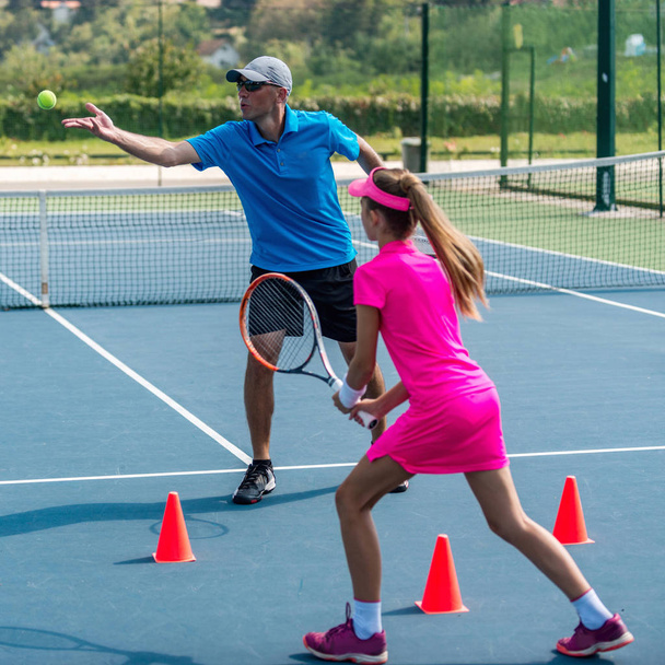 entrenador masculino con chica en el entrenamiento de tenis
 - Foto, imagen