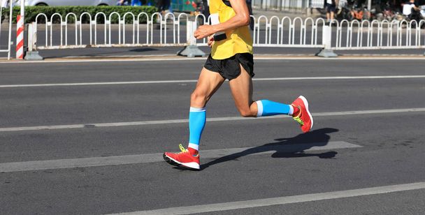 市の道路上で実行マラソン ランナーの足 - 写真・画像