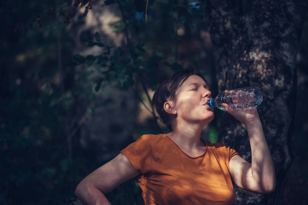 Mujer bebiendo agua al aire libre
 - Foto, Imagen