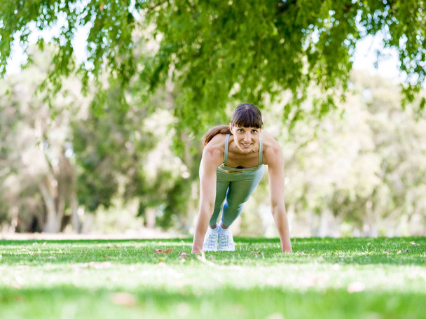 Young woman exercising in the park - Foto, imagen