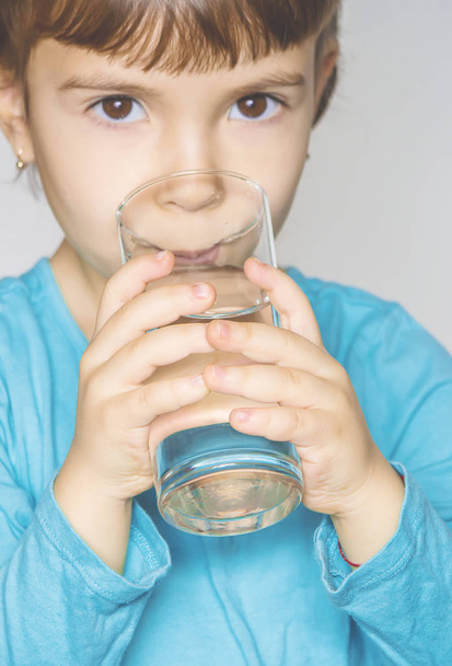 A child is holding a glass of water. Selective focus.  - Valokuva, kuva