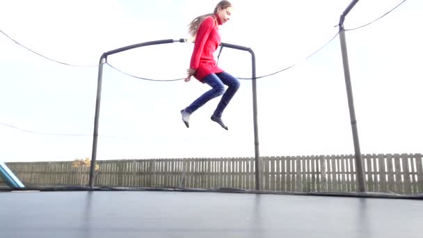 Mooi meisje springen op de trampoline in een herfst park. - Video