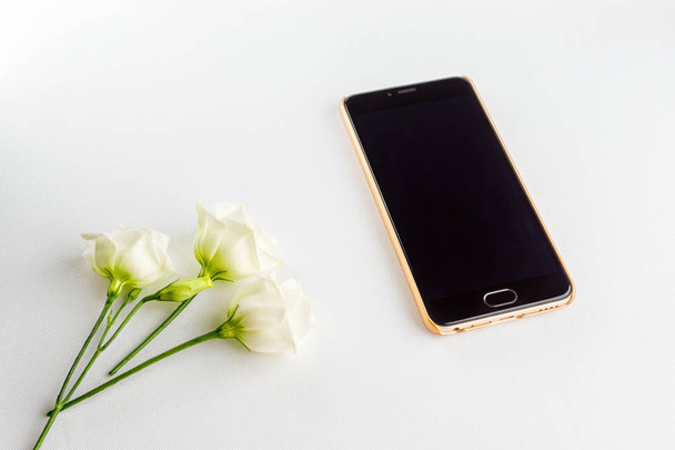 Delicate white flowers and modern powerful smartphone - Φωτογραφία, εικόνα