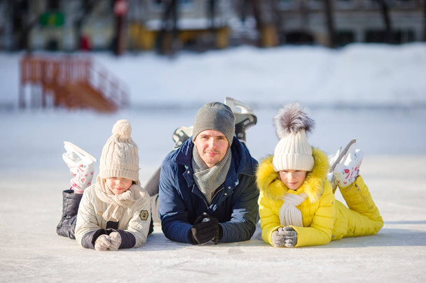Perhe nauttii talviurheilusta jäähallilla ulkona
 - Valokuva, kuva