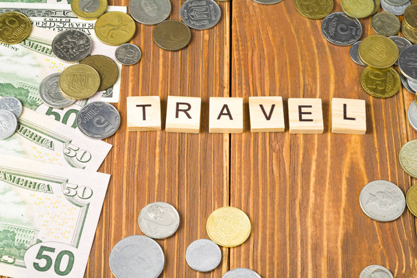 Word TRAVEL on wooden cubes with money frame at wood background.Financial concept - Photo, image