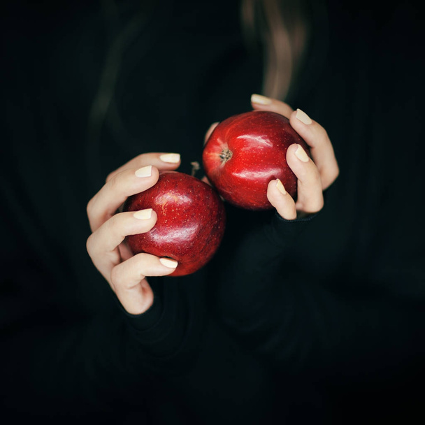 woman hands holding some red apples, sensual studio shot with black backgound - Photo, image