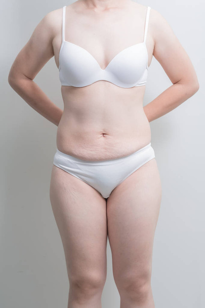 Fat overweight woman standing on grey  background, asian - Zdjęcie, obraz