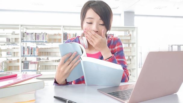 азиатка студентка учится и чувствует усталость в библиотеке
 - Фото, изображение