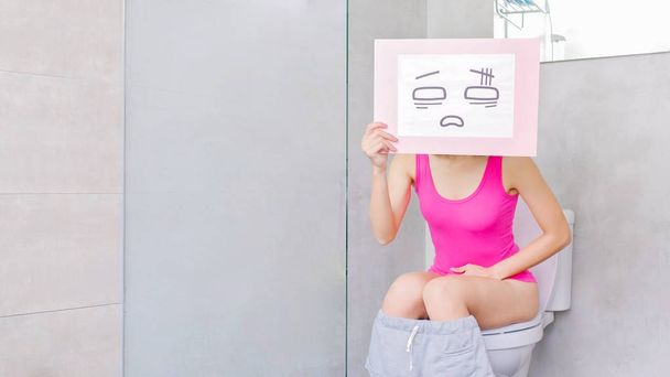 woman  with constipation in the toilet with confuse billboard - 写真・画像