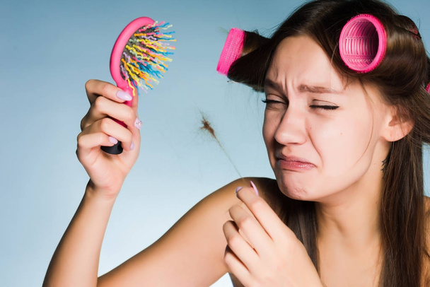 girl with curlers on her head upset with hair loss - Φωτογραφία, εικόνα