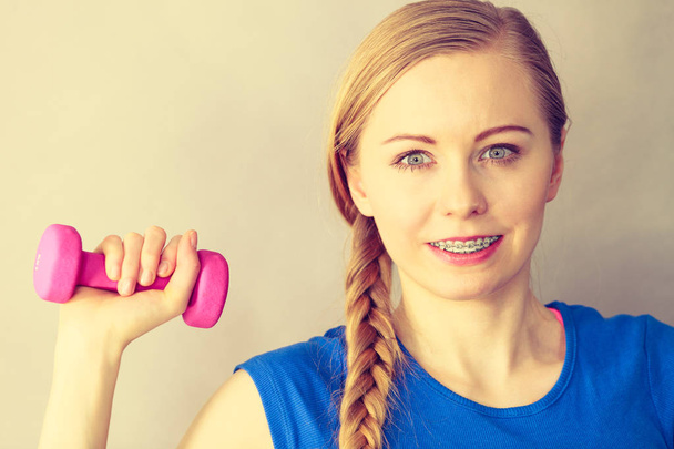 Teenage woman working out at home with dumbbell - Valokuva, kuva