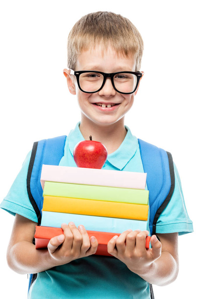 écolier souriant avec des lunettes avec une pile de livres et un rouge
  - Photo, image