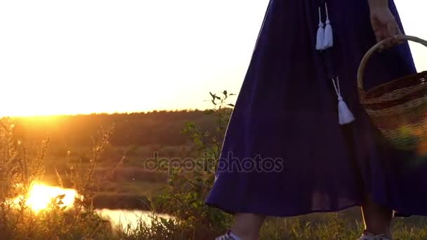 Speelse vrouw gaat en draait een folk mand bij zonsondergang in slo-mo - Video
