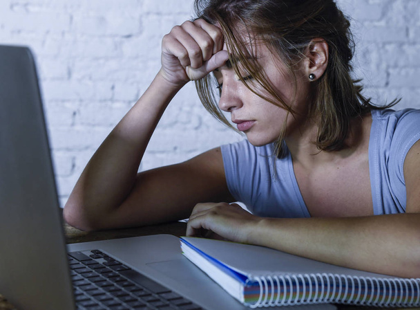 κουρασμένος μαθητής γυναίκα που εργάζεται σε φορητό υπολογιστή με το notepad αίσθημα απογοητευμένος και εξαντλημένος σπουδάζουν για εξετάσεις αργά τη νύχτα - Φωτογραφία, εικόνα