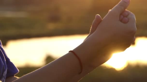 Mãos femininas batem uma na outra ternamente ao pôr do sol em slo-mo
 - Filmagem, Vídeo