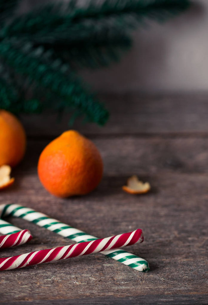Tangerine and candy canes on wooden table. Christmas mood. - Fotografie, Obrázek