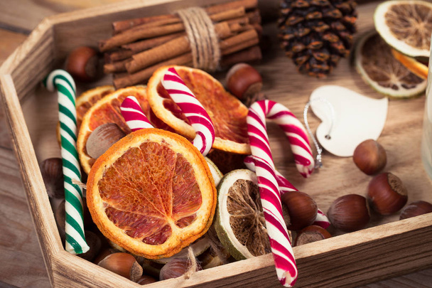 Candy canes with dehydarted oranges slices with hazelnuts. Top view. - Φωτογραφία, εικόνα