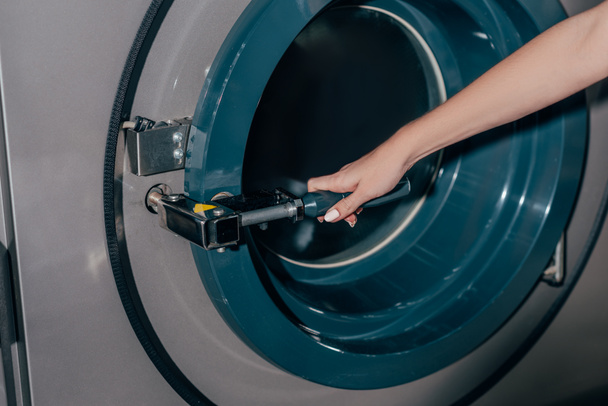 обрізаний знімок жінки, що відкриває промислову пральну машину
 - Фото, зображення