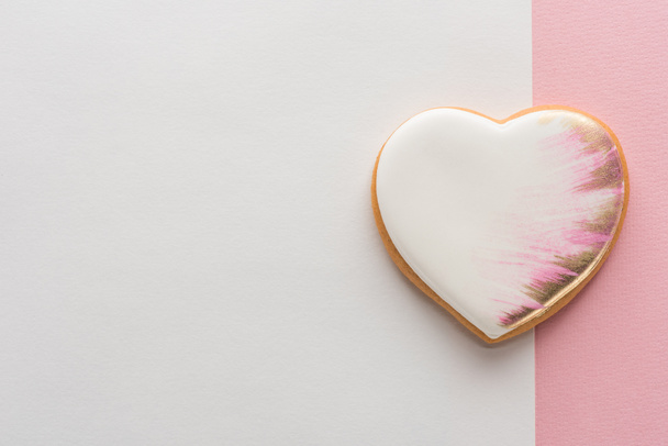 top view of glazed heart shaped cookie on pink surface - Fotó, kép