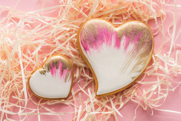 tatlı kalp şeklinde kurabiye ve pembe, st Sevgililer tatil kavramı üzerinde dekoratif saman görünümünü kapat - Fotoğraf, Görsel