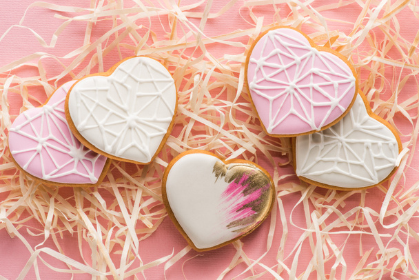 close up view of sweet heart shaped cookies and decorative straw on pink, st valentines holiday concept - Foto, immagini