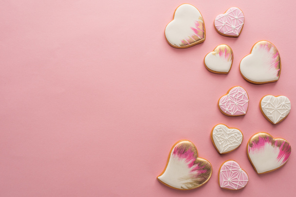 flat lay with arrangement of glazed heart shaped cookies isolated on pink surface - Photo, Image