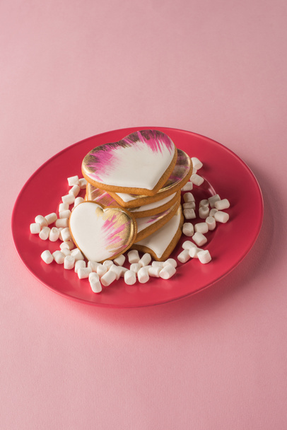 close up view of heart shaped cookies and marshmallow on plate isolated on pink - Photo, Image