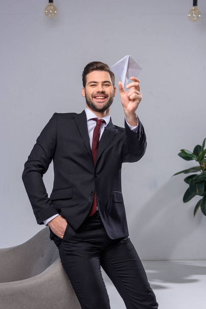 happy businessman throwing paper plane in office - Foto, Imagem