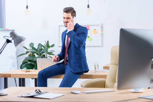 happy businessman talking by smartphone in office - Фото, зображення