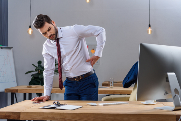 young businessman having pain in back - Zdjęcie, obraz