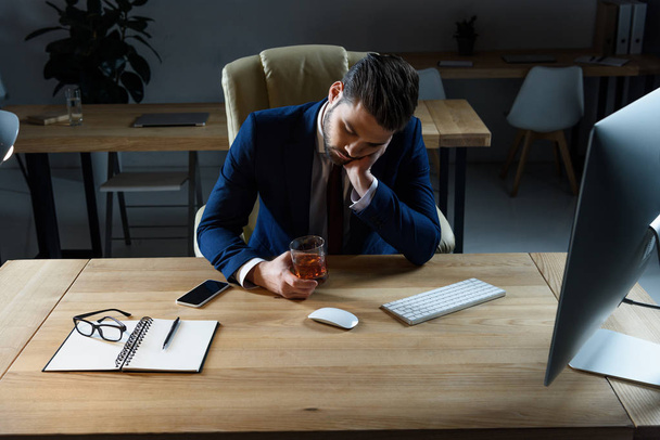 homme d'affaires ivre fatigué assis avec un verre de whisky au bureau
 - Photo, image