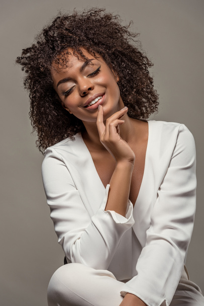 Fiatal érzéki afrikai-amerikai nő a fehér ing ujj ajkak elszigetelt szürke háttér - Fotó, kép