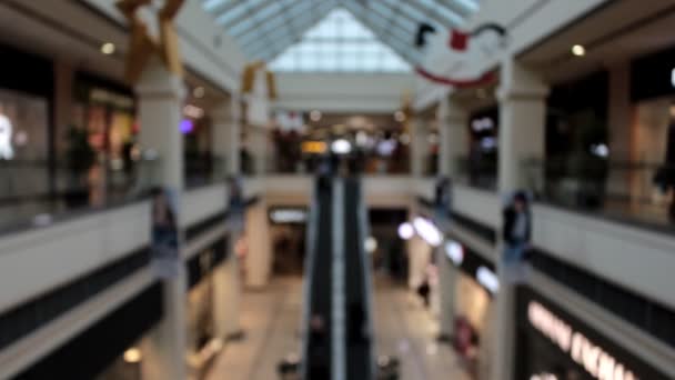 Centro comercial simétrico desenfocado con las escaleras mecánicas y las personas que caminan
 - Metraje, vídeo