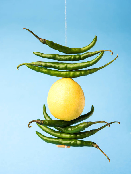 citronové chilli visí - indické pověrčivý citron a zelené chilli papričky remizoval s vlákno a svázané na dveře doma nebo obchodě, aby se zabránilo jakékoliv špatné štěstí také známý jako totka nebo nazar battu - Fotografie, Obrázek