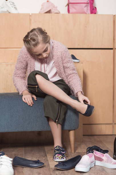 ребенок сидит и примеряет новые туфли в магазине
  - Фото, изображение