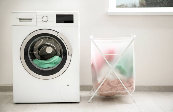 Laundry basket and washing machine indoors - Photo, image