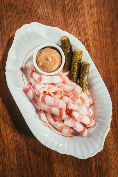 «Ana sayfa» sos ile ve turşusu dilimli pastırma görünümünü salatalık ahşap masa üzerinde plaka üzerinde - Fotoğraf, Görsel