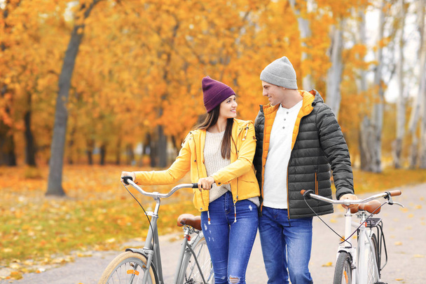 Young couple walking with bicycles in park - Fotoğraf, Görsel