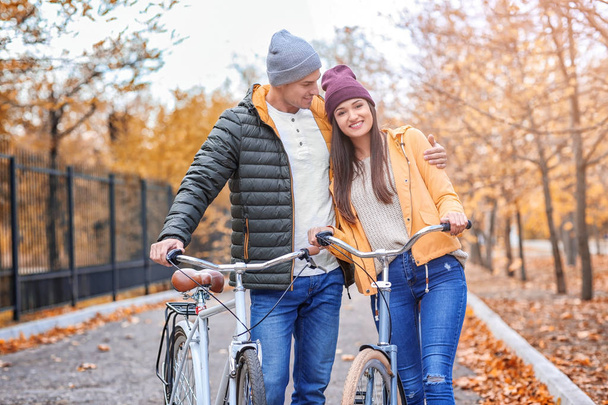 Young couple walking with bicycles in park - Foto, Imagem
