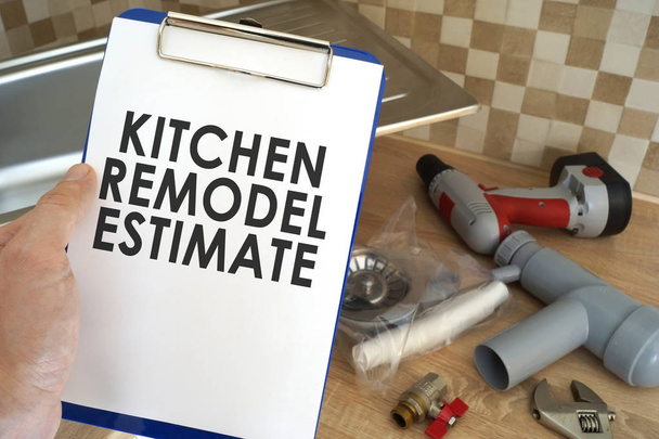 Plumber taking clipboard with kitchen remodel estimate. - Foto, Imagen