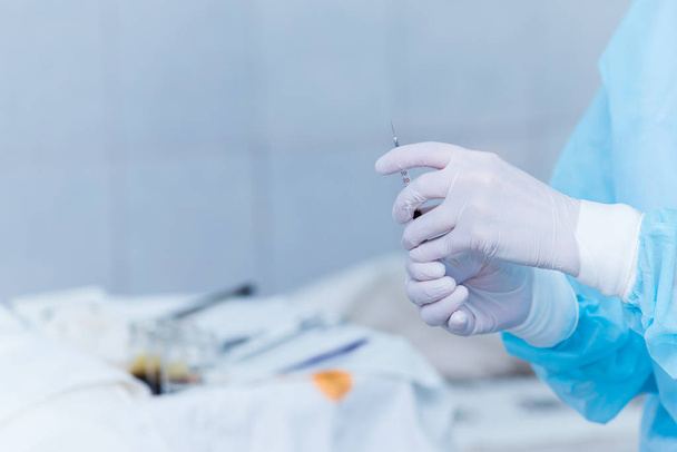 the hands of the anesthesiologist with a syringe in his hand. concept photo of medicine without the pain - Fotó, kép