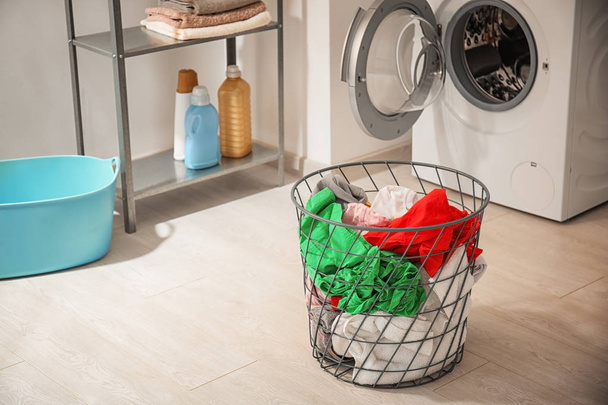 Basket with laundry and washing machine in bathroom - 写真・画像